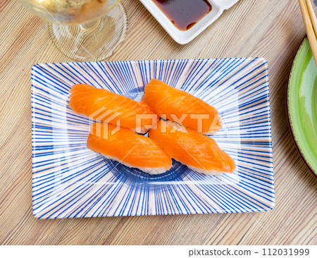 Nigiri sushi with salmon. Delicious traditional Japanese food, tasty seafood, restaurant concept Nigiri sushi with salmon. Delicious traditional Japanese food, tasty seafood, restaurant concept 112031999