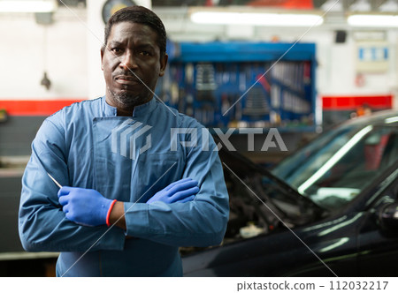 Portrait of african male mechanician posing in workshop 112032217