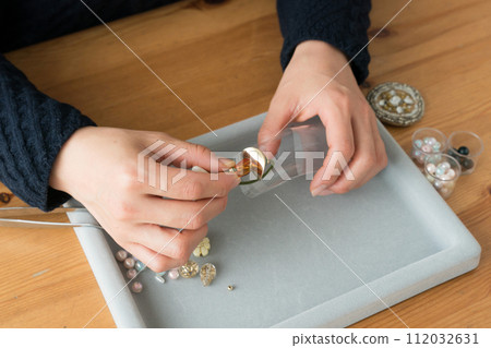 Woman's hands packing accessories 112032631