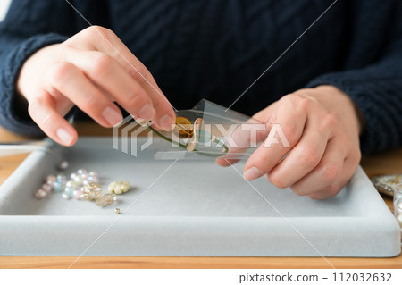 Woman's hands packing accessories 112032632