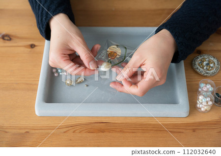 Woman's hands packing accessories 112032640