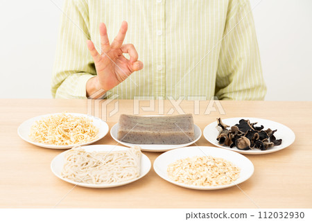 A middle-aged woman makes a circle sign indicating foods that are high in dietary fiber. A middle-aged woman makes a circle sign indicating foods that are high in dietary fiber. 112032930