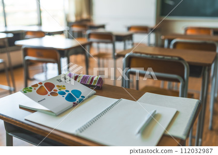 Textbooks and notebooks placed on classroom desks 112032987