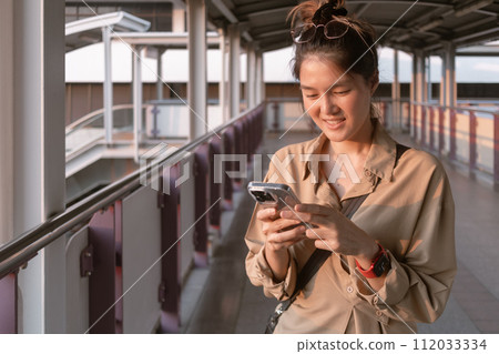 Woman is using mobile phone on the city bridge in Bangkok. Woman is using mobile phone on the city bridge in Bangkok. 112033334