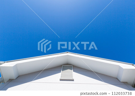 Looking up at the roof and blue sky 112033738