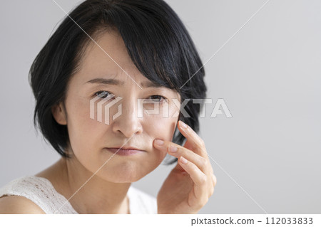 Woman in her early 50s concerned about fine lines, skin problems, beauty image, portrait 112033833