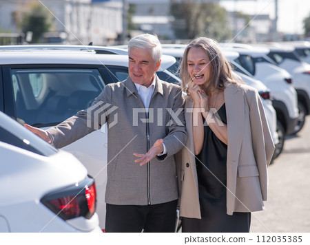 An elderly Caucasian man gives a new car to his beloved woman. An elderly Caucasian man gives a new car to his beloved woman. 112035385