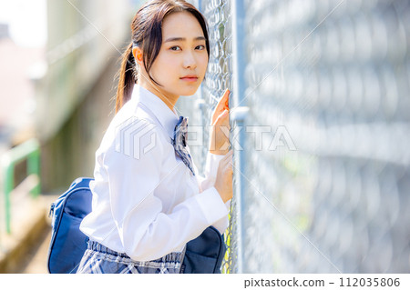 School girls wearing uniforms in front of the school building 112035806