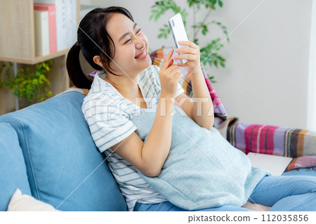 年輕女子在客廳看智慧型手機 112035856