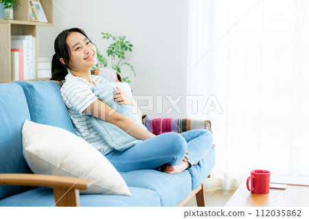 Young woman relaxing in the living room Young woman relaxing in the living room 112035862