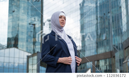 Portrait of a pregnant business woman in hijab and suit outdoors. 112036172