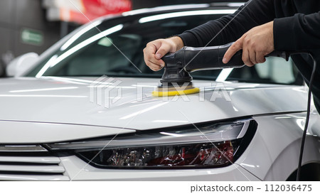 Process of polishing white car hood surface using orbital polishing machine.  112036475