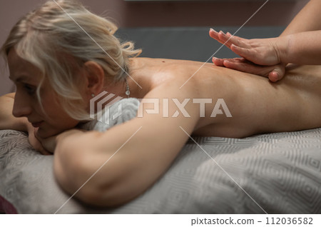 Woman having a therapeutic back massage. Woman having a therapeutic back massage. 112036582