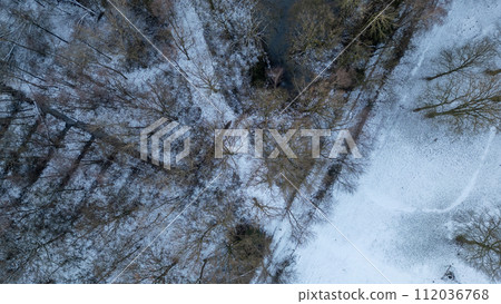 Wintery Aerial Tapestry: A Bird's Eye View of Snow-Dusted Woodland and Stream 112036768