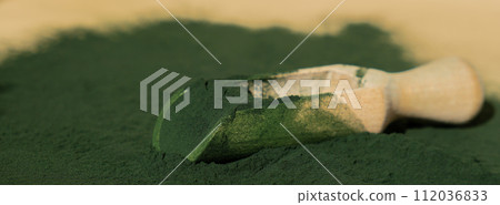 Natural organic green spirulina algae powder in wooden spoon on neutral background. Chlorella seaweed vegan superfood supplement source and detox. Copy space Healthy nutritional antioxidant 112036833
