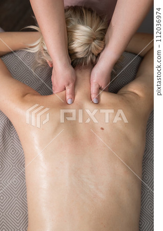 Top view of a woman undergoing a cervical-neck massage. Vertical photo. Top view of a woman undergoing a cervical-neck massage. Vertical photo. 112036974