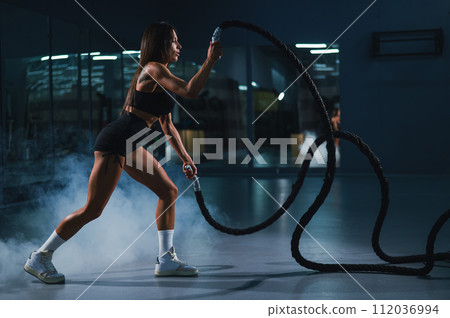 Caucasian woman doing exercise with ropes. Caucasian woman doing exercise with ropes. 112036994