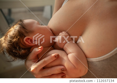 Caucasian woman breastfeeds her four-month-old son. Caucasian woman breastfeeds her four-month-old son. 112037134