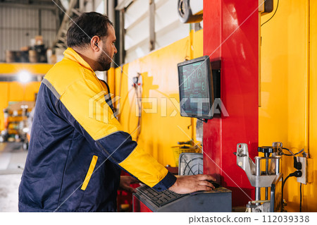 mechanic male worker using advance computer technology for tuning checking analysing car problem in auto salon service workshop mechanic male worker using advance computer technology for tuning checking analysing car problem in auto salon service workshop 112039338