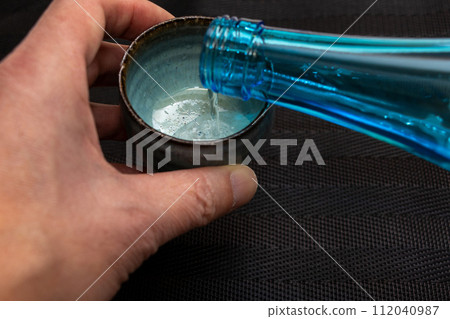 Pour sake into the choko in your hand Pour sake into the choko in your hand 112040987