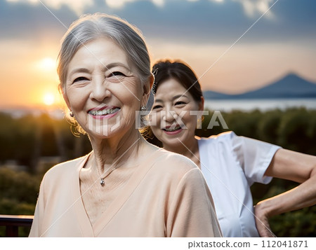 Elegant residents and their veteran caregivers looking out at the view from the roof of a nursing home Elegant residents and their veteran caregivers looking out at the view from the roof of a nursing home 112041871