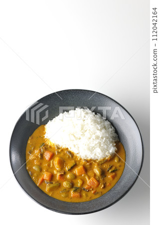 白色背景下咖哩飯的頭頂照片，裡面有豬肉、南瓜和胡蘿蔔等大量蔬菜 112042164