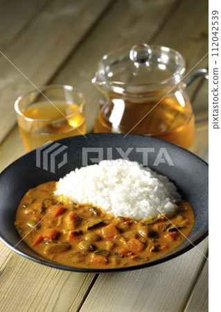 Curry rice and tea with plenty of vegetables such as pork, pumpkin, and carrots. Curry rice and tea with plenty of vegetables such as pork, pumpkin, and carrots. 112042539