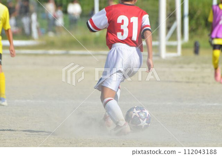 Youth soccer match (player dribbling) 112043188