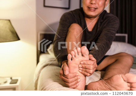 Asian middle aged man have severe cramp his calf muscle of leg,adult male people suffering from cramps of foot,problems of peripheral neuropathy,numbness or weakness in leg,beriberi in feet and toes Asian middle aged man have severe cramp his calf muscle of leg,adult male people suffering from cramps of foot,problems of peripheral neuropathy,numbness or weakness in leg,beriberi in feet and toes 112043670