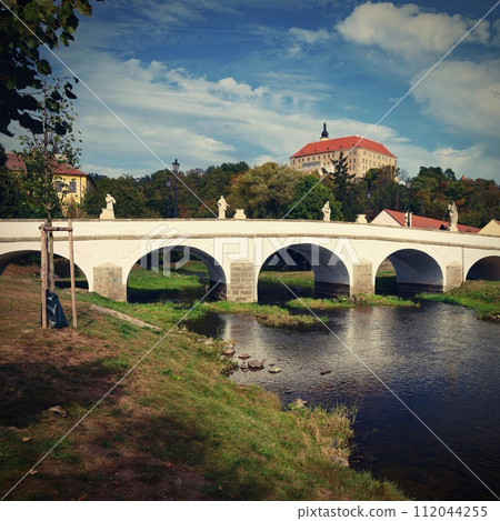 Beautiful old castle with a bridge over the river at sunset. European old architecture. Namest nad Oslavou - a city in the Czech Republic. 112044255