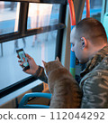 AI-generated content. A man with a cat and smartphone in public transport. High quality photo 112044292