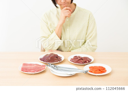 A middle-aged woman worries about foods that contain a lot of B vitamins. A middle-aged woman worries about foods that contain a lot of B vitamins. 112045666