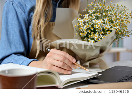 Assembling a bouquet of flowers with florist's tools. 112046336