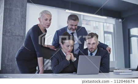 Concentrated colleagues waiting for business project results, looking at laptop screen Concentrated colleagues waiting for business project results, looking at laptop screen 112046674