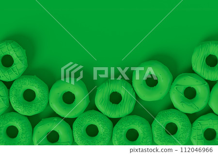 Isometric view of glazed donut with sprinkles on plain monochrome green color Isometric view of glazed donut with sprinkles on plain monochrome green color 112046966