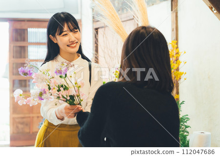 Female customer buying flowers Female customer buying flowers 112047686