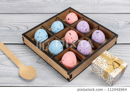 Colorful Easter eggs in a box and a gift box on the wooden background 112048964