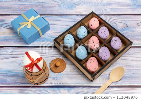 Colorful Easter eggs in a box with kitchen accessories. Colorful Easter eggs in a box with kitchen accessories. 112048976