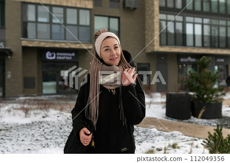 Lifestyle concept, young pretty woman with dreadlocks hairstyle wearing a black coat 112049356
