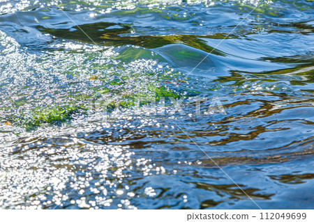 flow of water and spray from a stone 112049699