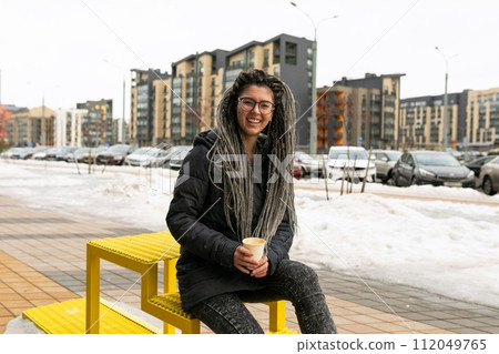 Cute young woman with dreadlock hairstyle dressed casually in the city Cute young woman with dreadlock hairstyle dressed casually in the city 112049765