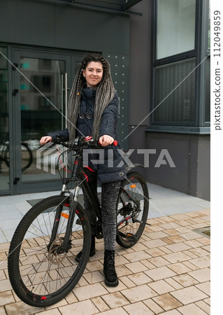 Bike rental concept, young caucasian woman riding a bike on the street 112049859