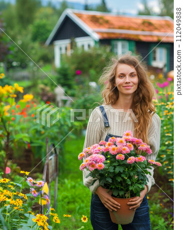 Young woman gardening in greenhouse.She selecting flowers. 112049888