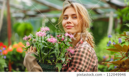Young woman gardening in greenhouse.She selecting flowers. 112049946