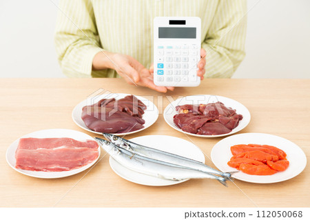 中年婦女拿著含有大量 B 群維生素的食物和計算器 112050068