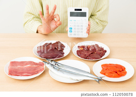 一名中年婦女拿著富含 B 群維生素的食物和計算器,畫了一個圓圈。 一名中年婦女拿著富含 B 群維生素的食物和計算器,畫了一個圓圈。 112050078