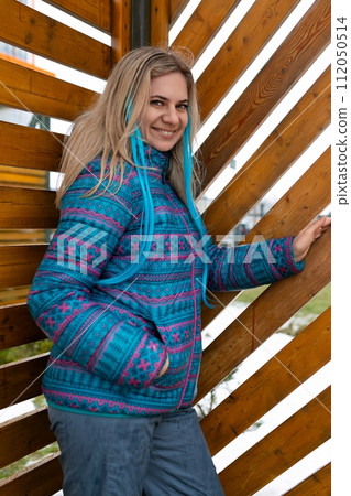Lifestyle concept. A woman in a blue jacket with a colored strand in her hair walks on the street in 112050514