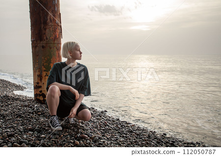 Outdoor portrait of young blonde woman with short bob hairstyle on sea beach Outdoor portrait of young blonde woman with short bob hairstyle on sea beach 112050787