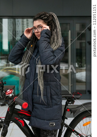 Photo on the street, a young woman took her bike for a walk in winter Photo on the street, a young woman took her bike for a walk in winter 112051151