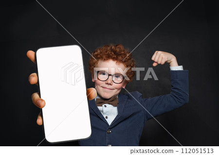 Happy kid boy holding smartphone with empty blank screen. Child playing game, surfing online 112051513
